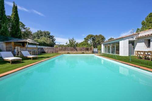 une grande piscine avec de l'eau bleue dans une cour dans l'établissement Villa Harmonie, au Beausset