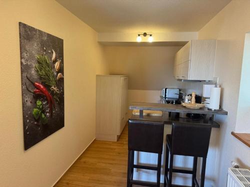a kitchen with a counter and some chairs in a room at Charmante Ferienwohnung in Neukloster mit Terrasse in Neukloster