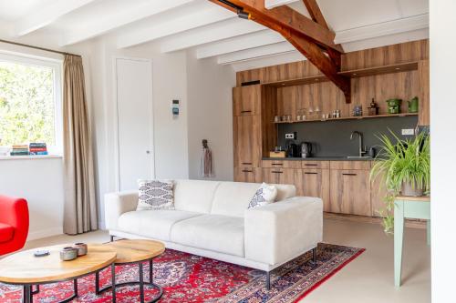 a living room with a white couch and a table at B&B Deventer Diekschuur in Deventer