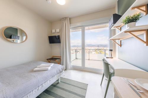 une chambre avec un lit et une grande fenêtre dans l'établissement Student Factory Clermont République, à Clermont-Ferrand
