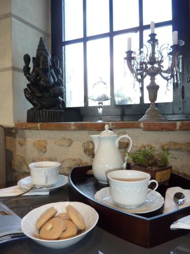 a table with plates of cookies and cups on it at Moulin de la Chevriere in Saché