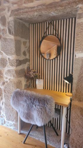 a table with a furry chair and a mirror at O lar de Cabanas in Brion