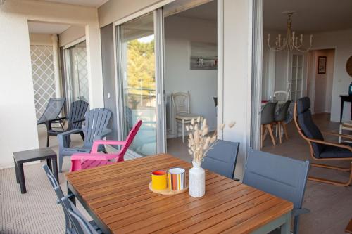 une table et des chaises en bois dans un salon dans l'établissement Spacieux Appartement Vue Pins-Tout à Pied-Résidence Le Manégore, à La Baule