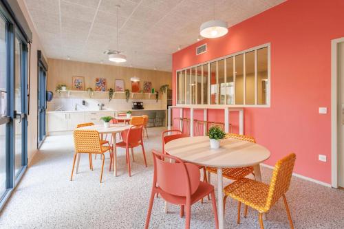 une salle à manger avec deux tables et des chaises dans l'établissement Student Factory Clermont République, à Clermont-Ferrand