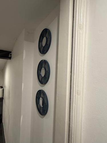 three black plates hanging on a wall at Snuggle Cove Apartments- Walton Road in Liverpool