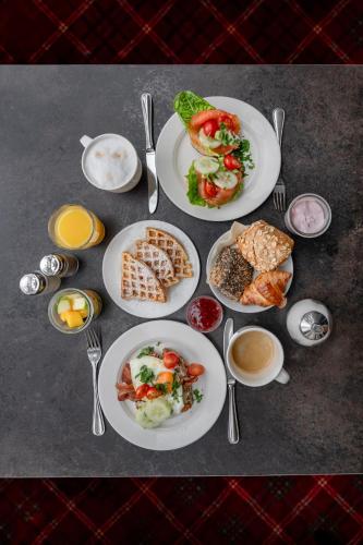 a table topped with plates of food and utensils at Best Western Plus Hotel St. Raphael in Hamburg