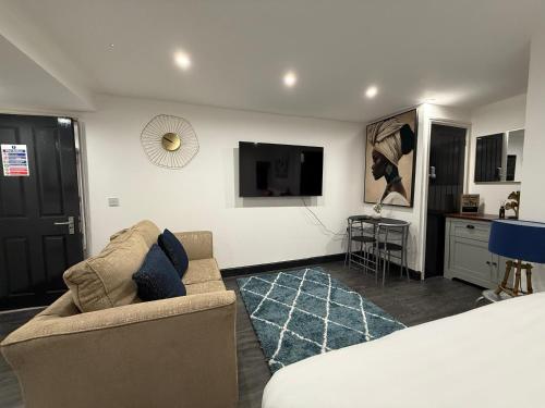 a living room with a couch and a flat screen tv at Snuggle Cove Apartments- Walton Road in Liverpool