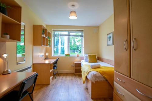 a bedroom with a bed and a desk and a window at 131 - Spacious 2 Bed Apt with Parking in Galway