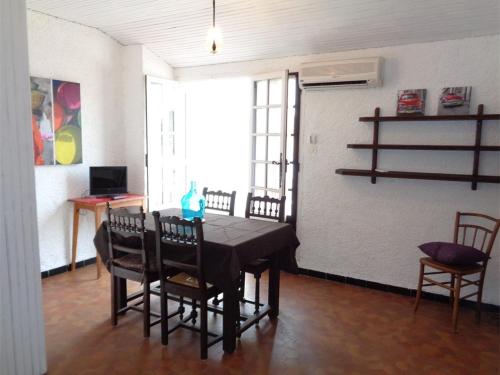 - une salle à manger avec une table, des chaises et un mur dans l'établissement Appartement T2 avec Terrasse, Clim et Parking à 200m de la Plage - FR-1-388-114, à Argelès-sur-Mer