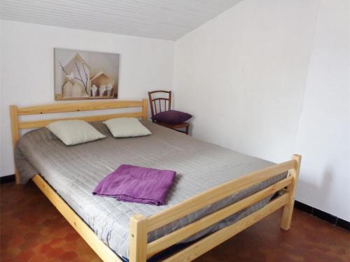 - une chambre avec un lit en bois et des draps violets dans l'établissement Appartement T2 avec Terrasse, Clim et Parking à 200m de la Plage - FR-1-388-114, à Argelès-sur-Mer