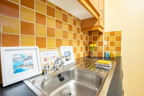 a kitchen sink with two pictures on the counter at 131 - Spacious 2 Bed Apt with Parking in Galway