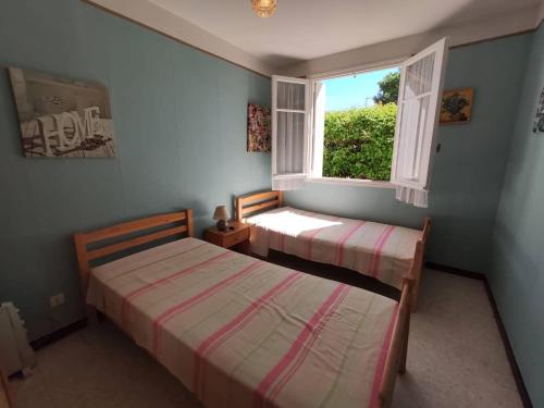 deux lits dans une chambre avec une fenêtre dans l'établissement Appartement T2 avec Parking à 200m de la Plage - FR-1-388-93, à Argelès-sur-Mer