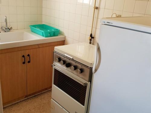 Il comprend une cuisine équipée d'une cuisinière et d'un réfrigérateur blanc. dans l'établissement Appartement T2 avec Parking à 200m de la Plage - FR-1-388-93, à Argelès-sur-Mer