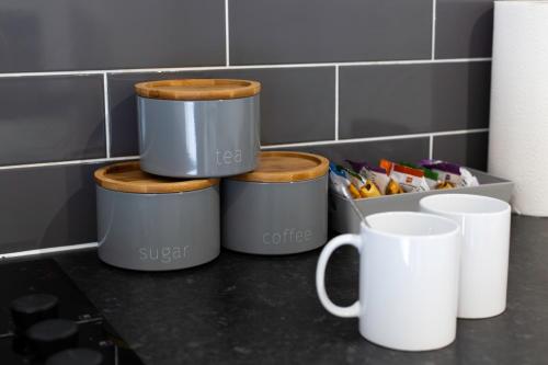 a group of four containers on a counter with cups at Snuggle Cove Apartments- Walton Road in Liverpool
