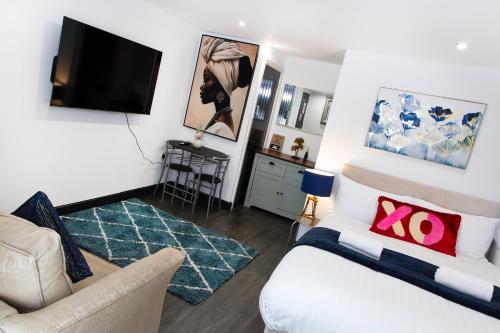 a living room with a couch and a tv at Snuggle Cove Apartments- Walton Road in Liverpool
