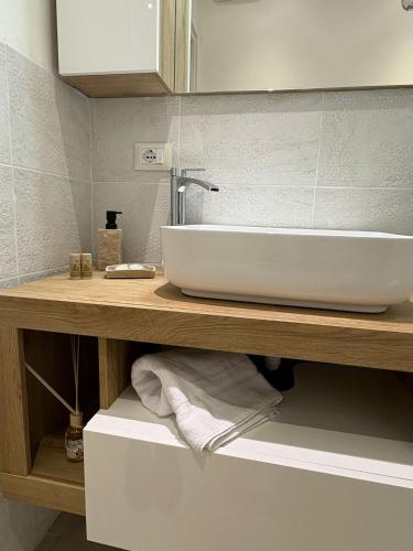 a bathroom with a white sink on a wooden counter at LeRoccheRoom in Monreale