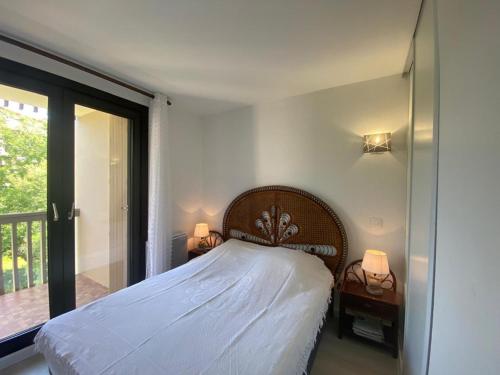une chambre avec un lit avec deux lampes et un balcon dans l'établissement Appartement T2 avec véranda, sur le port de Capbreton, proche commodités, pouvant accueillir 4 pers. - FR-1-413-177, à Capbreton