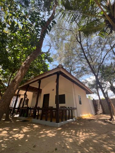 a small white building with a gambrel roof at Sand Dune Beach Resort & Surf Camp in Arugam Bay
