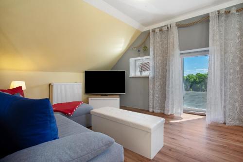 a living room with a couch and a flat screen tv at Julenhof in Loitz