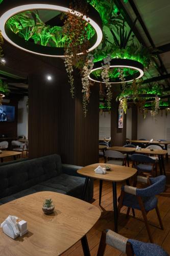 a restaurant with tables and green plants on the ceiling at Graphica Tbilisi Hotel in Tbilisi City