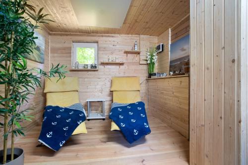 two chairs in a room with wooden walls at Julenhof in Loitz