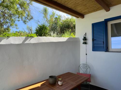 a patio with a wooden table and a fence at La casa del Geologo in Stromboli