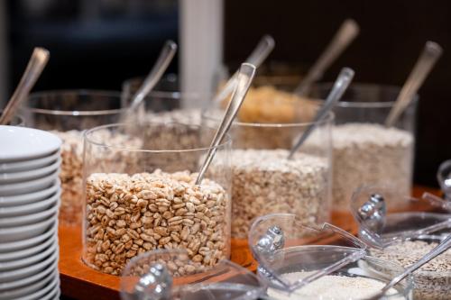 a table with three containers of oats and plates at Best Western Plus Hotel St. Raphael in Hamburg