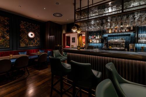 a bar with green chairs and tables in a restaurant at Best Western Plus Hotel St. Raphael in Hamburg