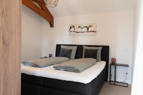 two beds in a room with white walls at B&B Deventer Diekschuur in Deventer