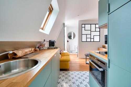 une cuisine avec un évier et un comptoir dans l'établissement Cosy appart cœur de Paris 2 pers, à Paris