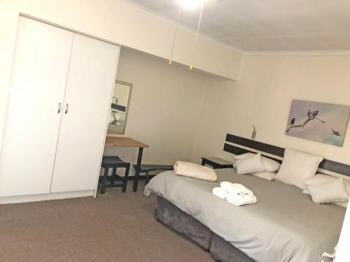 a bedroom with a bed with towels on it at Hills and Dales Accommodation in Lanseria