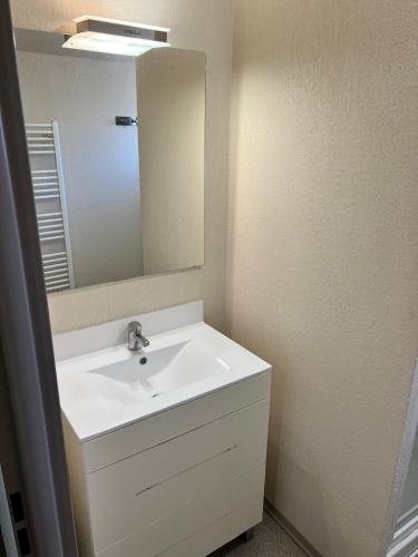 une salle de bain avec un lavabo blanc et un miroir dans l'établissement Natacha & Bacchus, à Saint-Christol