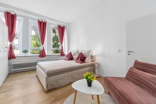 オッフェンバッハにあるApartment Ledermuseumのベッドとソファのある白い寝室