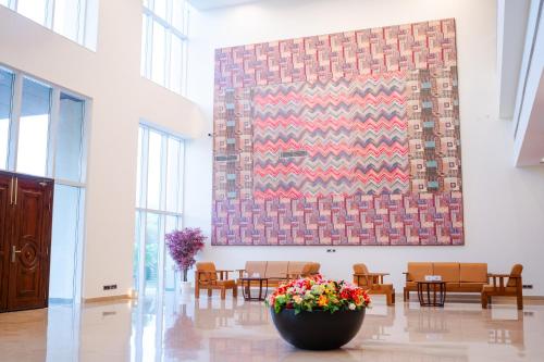 a large painting on the wall in a room with chairs at Eternal Oasis by Alaya Stays, Golf Course Road in Gurgaon