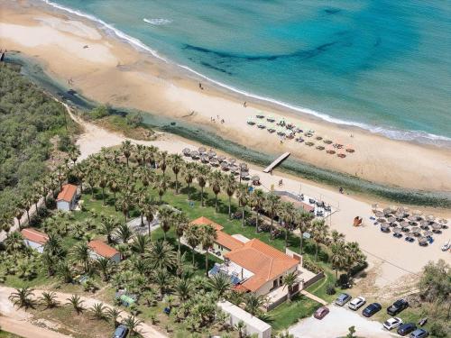 una vista aérea de una playa con palmeras y un complejo en La Palma Beachfront Suites, en Georgioupolis
