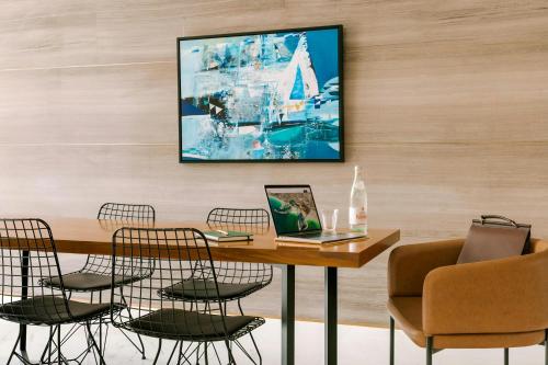 a dining room with a table with chairs and a laptop at Sonder by Marriott Bonvoy Downtown Towers Apartments in Dubai