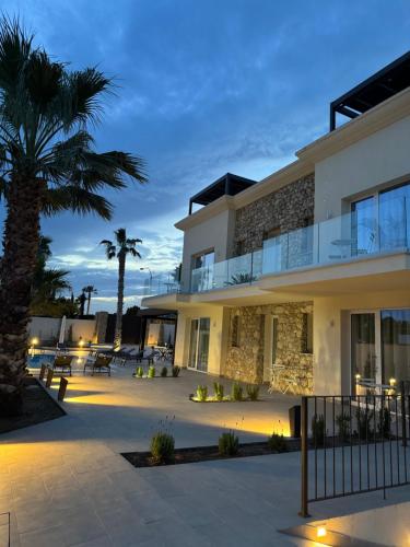 a building with a palm tree in front of it at Limonaia Luxury Villa in Porto Empedocle
