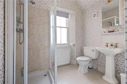 a bathroom with a shower and a toilet and a sink at Gruinard Guest House in Beauly