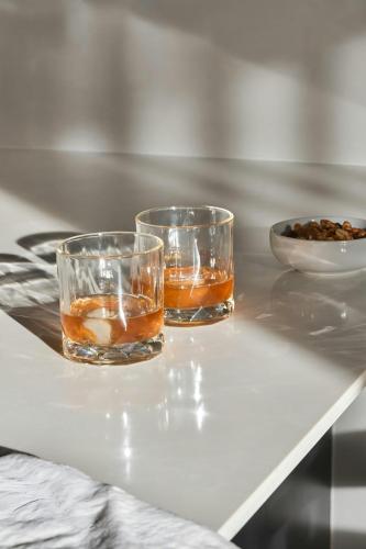 two glasses on a table with a bowl of food at Sonder by Marriott Bonvoy Britain Quay Apartments Grand Canal Square in Dublin