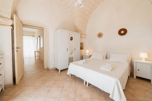 a white bedroom with a white bed in a room at CASA PAPADIA in Uggiano la Chiesa