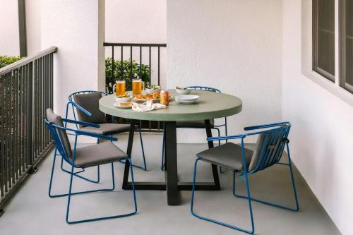 a table and chairs with drinks and food on a balcony at Sonder by Marriott Bonvoy Vista Cay Apartments in Orlando