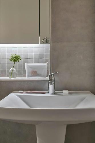 a white sink in a bathroom with a mirror at Sonder by Marriott Bonvoy Britain Quay Apartments Grand Canal Square in Dublin