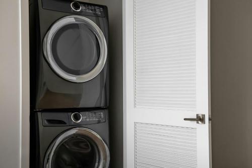 a washing machine and a dryer next to a door at Sonder by Marriott Bonvoy Britain Quay Apartments Grand Canal Square in Dublin