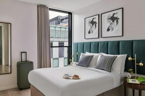 a bedroom with a large white bed and a window at Sonder by Marriott Bonvoy Britain Quay Apartments Grand Canal Square in Dublin