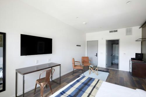 a living room with a desk and a tv on a wall at The Queen Hotel Queen Village, Sonder by Marriott Bonvoy in Philadelphia