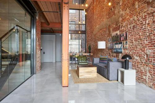 a living room with a brick wall and a couch at The Queen Hotel Queen Village, Sonder by Marriott Bonvoy in Philadelphia