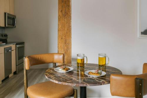 a table with two glasses of beer and plates of food at Sonder by Marriott Bonvoy The Burnham Apartments Loop in Chicago