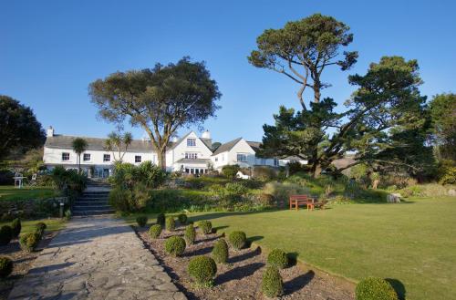a large white house with a garden in the foreground at Talland Bay Hotel, Looe in Talland