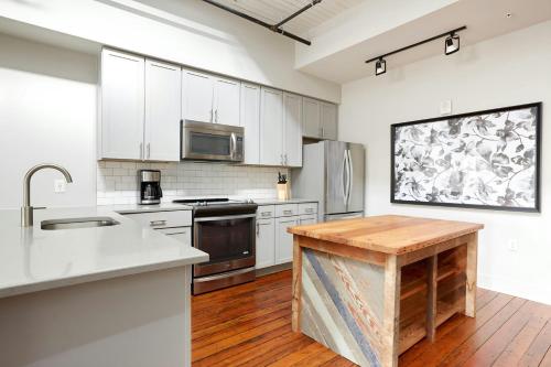 a kitchen with white cabinets and a wooden floor at Sonder by Marriott Bonvoy The Broughton Apartments Historic District in Savannah