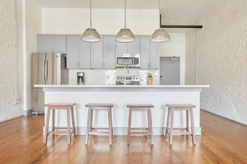 a kitchen with three bar stools and a counter at Sonder by Marriott Bonvoy The Broughton Apartments Historic District in Savannah